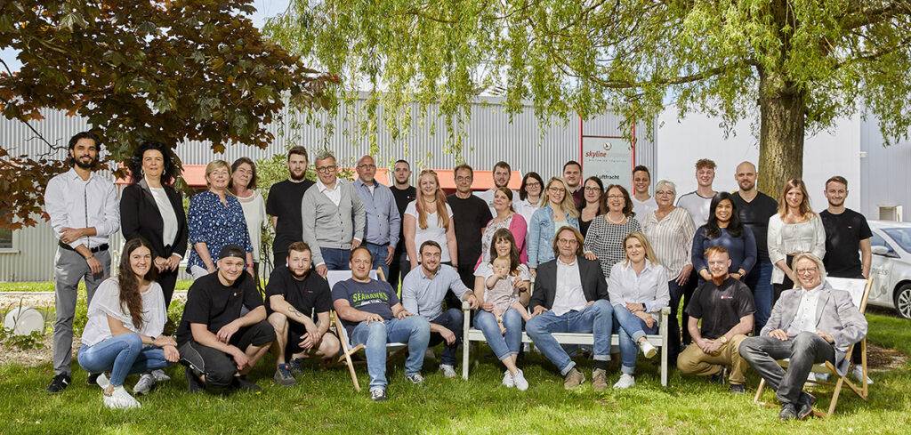 Alle Mitarbeiter auf einem Bild auf dem Rasen